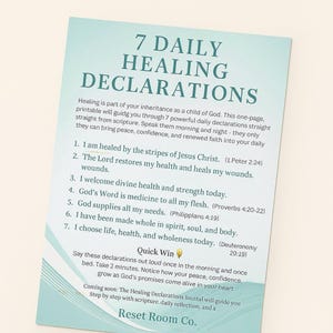 May include: A teal and white card with the title "7 Daily Healing Declarations" printed in large, bold letters. The card lists seven declarations with scripture references, encouraging daily affirmations for health and well-being. The card is from Reset Room Co.