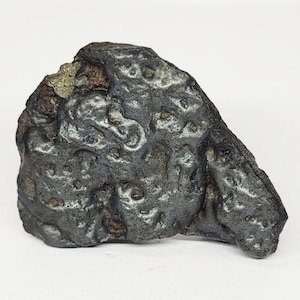 May include: A white ceramic mug with a black handle and the text "But First, Coffee" in a handwritten style. The mug is on a white surface. The mug is approximately 4 inches tall.