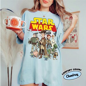 Camiseta retro de Toy Story y Star Wars de Comfort Colors®, camiseta de Woody Jedi y Buzz Lightyear, camiseta familiar de Galaxy's Edge del 4 de mayo, camiseta para viaje a Disney World. Chambray/Light Blue