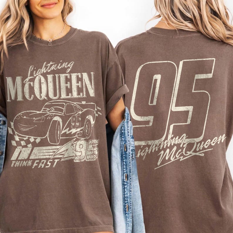 May include: Brown t-shirt with a Lightning McQueen design. The front shows the character, the number 95, and the words "THINK FAST." The back of the shirt has a large "95" and the text "Lightning McQueen".