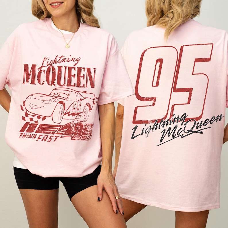 May include: Pale pink t-shirt with Lightning McQueen graphics. The front shows the character's name and image, plus the number 95 and the words "Think Fast." The back of the shirt has a large "95" and the character's name.