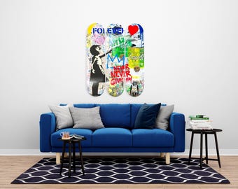 May include: Three skateboard decks with graffiti art hang above a blue sofa. The decks feature colorful designs, including a girl pointing, the word "FOREVER", and the phrase "NEVER GIVE UP". The room has a modern aesthetic with a black and white patterned rug.