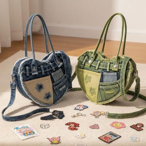 Op de afbeelding: Twee hartvormige denim handtassen, één blauw en één groen, met bijpassende bandjes. Elke tas heeft een patchwork ontwerp met verschillende denim tinten en een ritssluiting. Verspreid liggen kleurrijke geborduurde patches.