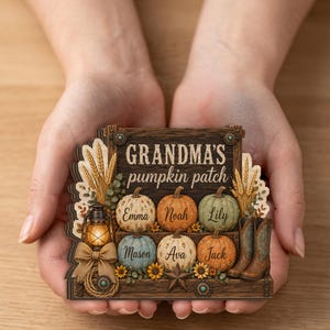 Può includere: Un cartello in legno a strati con la scritta "GRANDMA'S pumpkin patch" e sei zucche, ognuna etichettata con un nome: Emma, Noah, Lily, Mason, Ava e Jack. Il design include spighe di grano, una lanterna, un fiocco e stivali da cowboy.