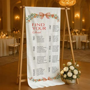 May include: A cream-colored wedding seating chart with floral and bow accents. The chart, displayed on a wooden easel, lists names under numbers one through nine. The words "FIND YOUR Seat" are at the top.