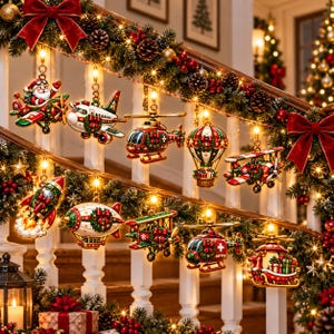 May include: A collection of hanging Christmas ornaments shaped like various vehicles including aeroplanes, helicopters, a rocket, a hot air balloon, and a sleigh, all decorated with red, green, and gold festive patterns and wreaths.