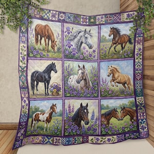 Op de afbeelding: Een gewatteerde deken met negen panelen, elk met een ander paard in een veld met paarse bloemen. De paarden variëren in kleur en pose, met een decoratieve rand van bloemen- en geometrische patronen in paars en groen.