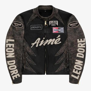 May include: Black distressed leather jacket with multiple patches and text. Features the words "Aimé" in white script across the chest, "LEON DORE" on the sleeves, and "CHAMPION" on a patch. Includes a zipper closure and various other patches.
