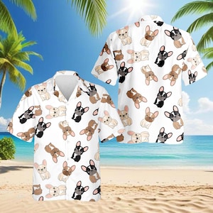 Op de afbeelding: Wit overhemd met korte mouwen met een herhaald patroon van cartoon Franse Bulldogs in zwart, bruin en crème. Het shirt heeft een klassieke kraag en is ideaal voor een relaxte, casual stijl. De achtergrond toont een strandscène.