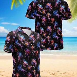 May include: Black button-down shirt with a vibrant pattern of colorful jellyfish. The jellyfish are in shades of blue, purple, and orange, set against a black background. The shirt has short sleeves and a classic collar.
