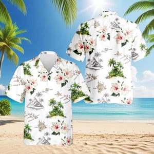 Puede incluir: Camisa hawaiana blanca con un estampado floral tropical y de paisaje isleño. La camisa muestra un diseño repetido de flores de hibisco, palmeras e ilustraciones de montañas. La camisa de manga corta tiene una parte delantera abotonada y un ajuste relajado.
