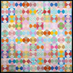 May include: A colorful quilt with a patchwork design featuring various floral and geometric patterns in shades of pink, blue, yellow, green, and red.