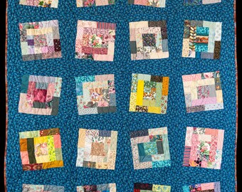 May include: A blue quilt with a patchwork design. Each square is made up of smaller squares of different fabrics, creating a unique and colorful pattern.