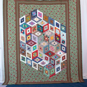 May include: A colorful quilt with a hexagonal pattern, featuring a variety of fabrics and colors, including red, blue, green, and yellow. The quilt is surrounded by a green and red border.
