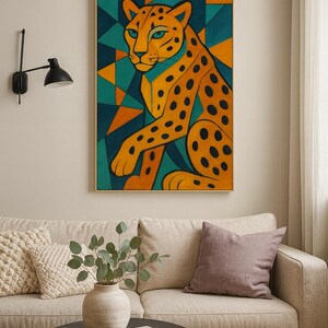 以下が含まれることがあります： スタイリッシュなチーターを描いた額入りのアートプリント。このアートワークは、ターコイズ、オレンジ、ゴールドの三角形の幾何学的な背景に対して、オレンジと黒の色合いで動物を描いています。プリントはベージュのソファの上にあります。