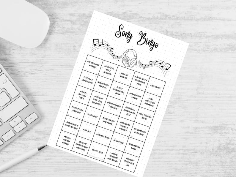 May include: A black and white "Song Bingo" game sheet with musical notes and a headphone graphic. The game sheet has a grid of squares with music-related prompts. A white keyboard, mouse, and pen are in the background.