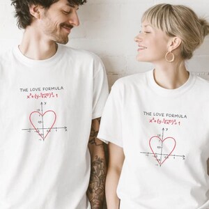 May include: A white ceramic mug with a black handle and the text "But First, Coffee" in a bold, black font. The mug is set against a blurred background, suggesting a cozy setting.