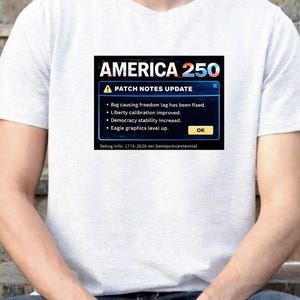 May include: A light gray t-shirt featuring a graphic that reads "AMERICA 250" with a "PATCH NOTES UPDATE" message. The update includes fixes for freedom lag, improved liberty calibration, increased democracy stability, and eagle graphics level up.