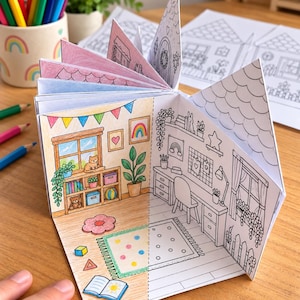Op de afbeelding: Een papieren knutselboek in de vorm van een huis met meerdere pagina's met zwart-wit lijntekeningen van kamerinterieurs. Sommige pagina's zijn gedeeltelijk ingekleurd met kleurpotloden, met een slaapkamer met een kat en een bureau.