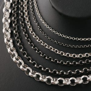 Puede incluir: Una taza de cerámica blanca con un asa negra y el texto "But First, Coffee" en negro, en negrita. La taza está sobre una superficie blanca.