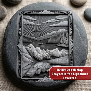 May include: A gray, engraved stone featuring a mountain landscape with a lake, trees, and a setting sun. The design is framed with a geometric border. Text on the stone reads "16-bit Depth Map Grayscale for Lightburn Inverted."