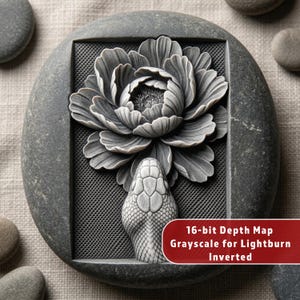 May include: A gray, carved stone with a floral design and a snake head. The flower is in a rectangular frame with a mesh background. The text on the image reads: "16-bit Depth Map Grayscale for Lightburn Inverted."