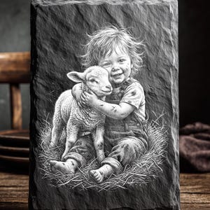 May include: A black slate plaque with a detailed engraving of a child hugging a lamb, seated in hay. The child is wearing overalls. The text "LASER READY PNG" is at the top. The image is in black and white.