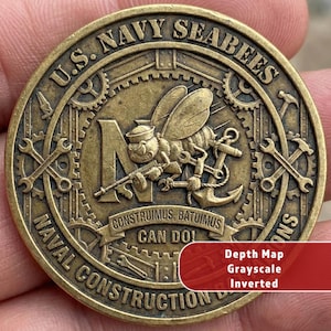 Op de afbeelding: Een bronzen U.S. Navy Seabees munt. De munt toont een cartoonbij met een geweer en anker, omringd door gereedschap en de tekst "CONSTRUIMUS, BATUIMUS CAN DO!". De munt heeft ook de tekst "U.S. NAVY SEABEES" en "NAVAL CONSTRUCTION".