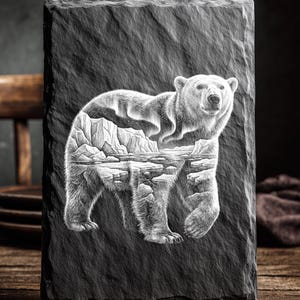 May include: A rectangular, dark gray slate plaque with a detailed engraving of a polar bear. The bear's body is filled with a landscape of mountains and water. The text "LASER READY PNG" is at the top.