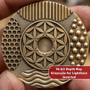 May include: A detailed, circular bronze-colored object with intricate patterns. The design includes a central flower-of-life pattern, dotted and striped textures, and the text "16-bit Depth Map Grayscale for Lightburn Inverted".