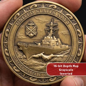 May include: A bronze United States Navy coin featuring a detailed depiction of a warship sailing on waves. The coin's edge has text that reads "UNITED STATES NAVY" and "SURFACE WARFARE - DOMINATE THE SEA". The coin is held by a person's hand.