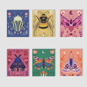 Könnte beinhalten: Set aus sechs Kunstdrucken mit farbenfrohen Insektenillustrationen. Die Designs umfassen einen Käfer, eine Biene und verschiedene Schmetterlinge und Motten, jeweils vor einem floralen Hintergrund. Die Drucke sind in Blau-, Rosa-, Grün- und Orangetönen gehalten.