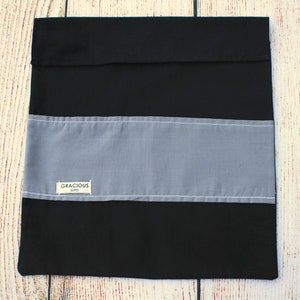 May include: A black and gray striped fabric gift bag with a white label that says "Gracious Gifts".