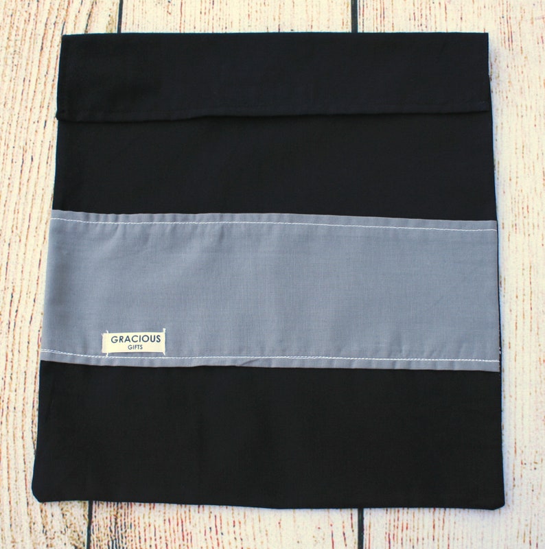 May include: A black and gray striped fabric gift bag with a white label that says "Gracious Gifts".