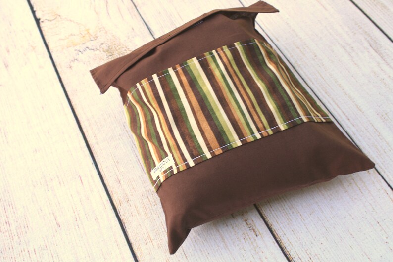 Puede incluir: Una bolsa de tela marr&oacute;n con un panel de tela a rayas. El panel tiene rayas marrones, verdes y beige. La bolsa tiene una etiqueta blanca que dice "Precious".