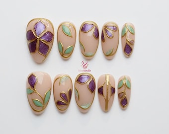 Unghie finte dipinte a mano con motivi floreali, elegante nail art color oro e verde smeraldo, unghie finte verdi colorate con vetrate regali, unghie floreali