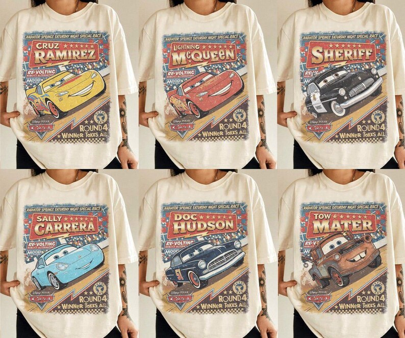 May include: A cream-coloured t-shirt featuring a vintage-style graphic print of Disney Pixar Cars characters including Cruz Ramirez, Lightning McQueen, Sheriff, Sally Carrera, Doc Hudson, and Tow Mater with the text Radiator Springs Saturday Night Special Race.