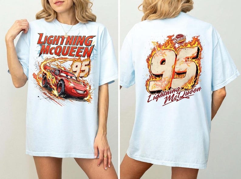 May include: A light blue t-shirt featuring a graphic of the red race car Lightning McQueen with the text Lightning McQueen and the number 95 on the front, and a large number 95 surrounded by flames with the text Lightning McQueen on the back.