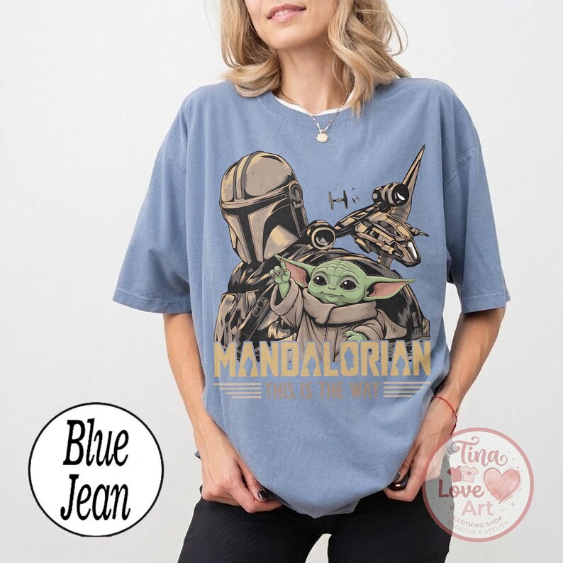 Pu&ograve; includere: T-shirt azzurra con una grafica di The Mandalorian e Grogu, un'astronave e la scritta "MANDALORIAN. This is the way." La maglietta ha maniche corte e una vestibilit&agrave; ampia.