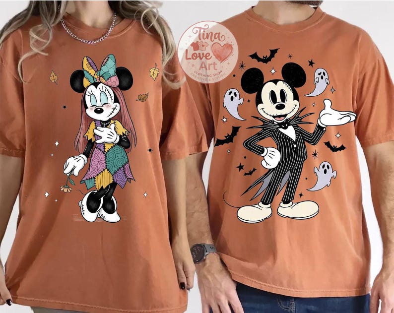 Op de afbeelding: Twee oranje T-shirts met Disney-figuren voor Halloween. E&eacute;n shirt toont Minnie Mouse in een patchwork jurk, de andere Mickey Mouse als Jack Skellington, omringd door vleermuizen en geesten. Onderdeel van een Halloween collectie.