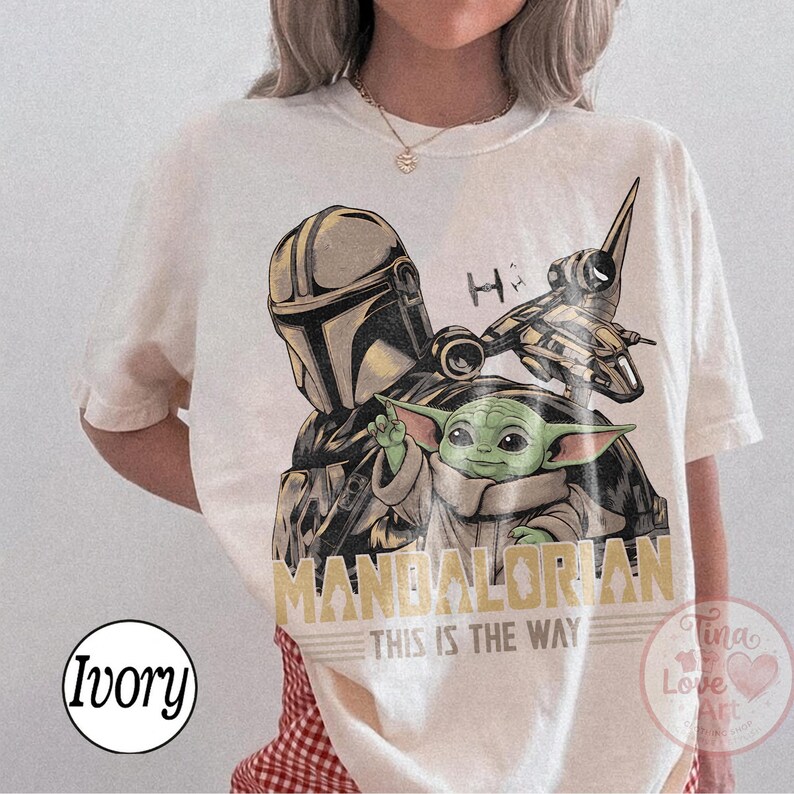 Pu&ograve; includere: T-shirt color avorio con grafica di The Mandalorian, Grogu e un'astronave. Il testo "MANDALORIAN" e "THIS IS THE WAY" &egrave; stampato in oro. La maglietta &egrave; girocollo.