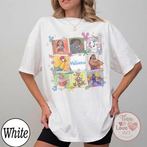 Puede incluir: Camiseta blanca con un gr&aacute;fico colorido de personajes de la pel&iacute;cula de Disney Moana. El dise&ntilde;o incluye im&aacute;genes de Moana, Maui, Hei Hei y Pua. La camiseta tiene mangas cortas y cuello redondo.