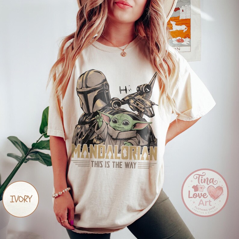 Pu&ograve; includere: T-shirt color avorio con grafica di The Mandalorian, Grogu e un'astronave. I testi "MANDALORIAN" e "THIS IS THE WAY" sono stampati sotto l'immagine. La maglietta ha una vestibilit&agrave; ampia.