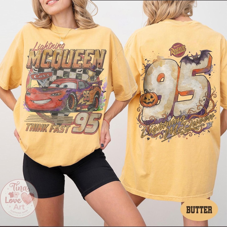 May include: A butter yellow t-shirt featuring a graphic of Lightning McQueen from Cars on the front with the text Lightning McQueen, Think Fast, and 95. The back displays a large 95 with a pumpkin, a bat, and the text Rusteze and Lightning McQueen.