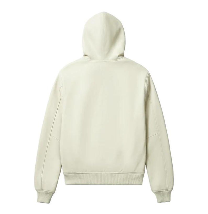 May include: Cream-colored hoodie with a drawstring hood and ribbed cuffs and hem. The back view of the sweatshirt shows a clean, minimalist design with a subtle seam detail on the sleeves. A casual, comfortable outerwear garment.