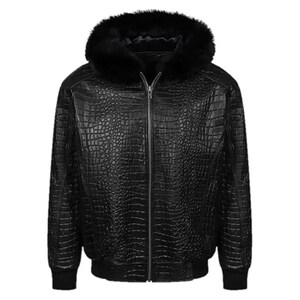 Puede incluir: Chaqueta de cuero negro con textura de piel de cocodrilo, capucha forrada de piel negra y cremallera completa. La chaqueta tiene un diseño tipo bomber con puños y dobladillo acanalados.