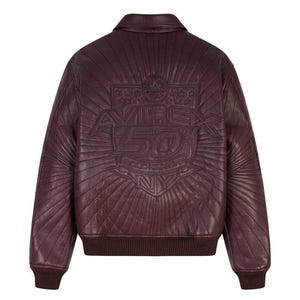 May include: A burgundy leather bomber jacket with a quilted design. The back features an embossed emblem with the text "AVIREX 50 GOLD KICKOFF NY". The jacket has a ribbed collar, cuffs, and hem.