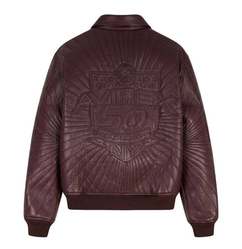 May include: A burgundy leather bomber jacket with a quilted design. The back features an embossed emblem with the text "AVIREX 50 GOLD KICKOFF NY". The jacket has a ribbed collar, cuffs, and hem.