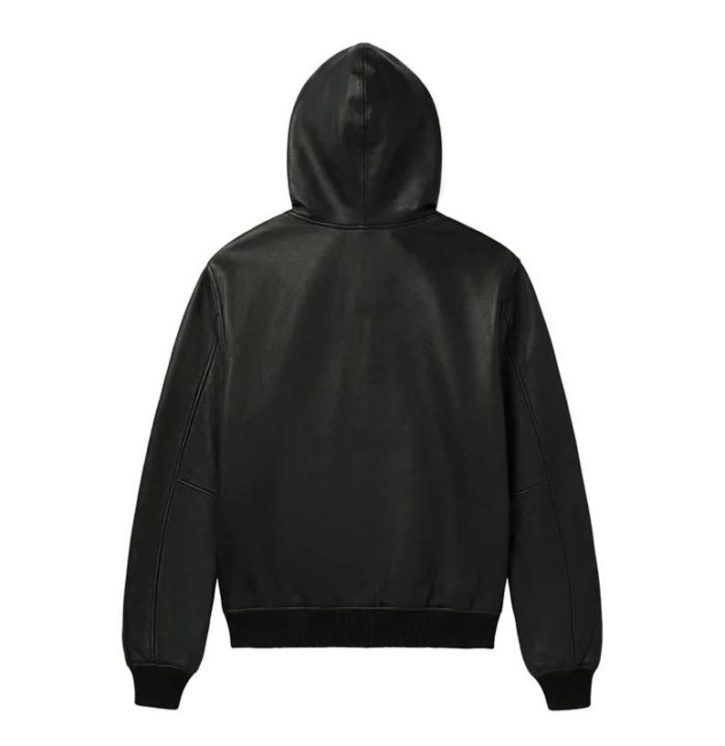 May include: A black leather jacket with a hood, viewed from the back. The jacket has a ribbed hem and cuffs. The hood is attached to the jacket and is made of the same material. The jacket appears to be a bomber style.