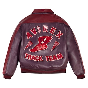 K&ouml;nnte beinhalten: Burgunderrote und violette Lederjacke mit dem Text "AVIREX TRACK TEAM USA" in wei&szlig;en Buchstaben. Die Jacke hat ein rotes Blitz- und Fl&uuml;geldesign mit gerippten B&uuml;ndchen und Kragen.